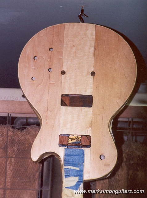 68lp1.jpg - The center of the top is routed out and replaced with a new piece of maple, all hand carved to match the original contours. The fingerboard and binding were removed and later replaced to accomplish this. New pickup routs and stop tailpiece anchor holes finished off the rough work.